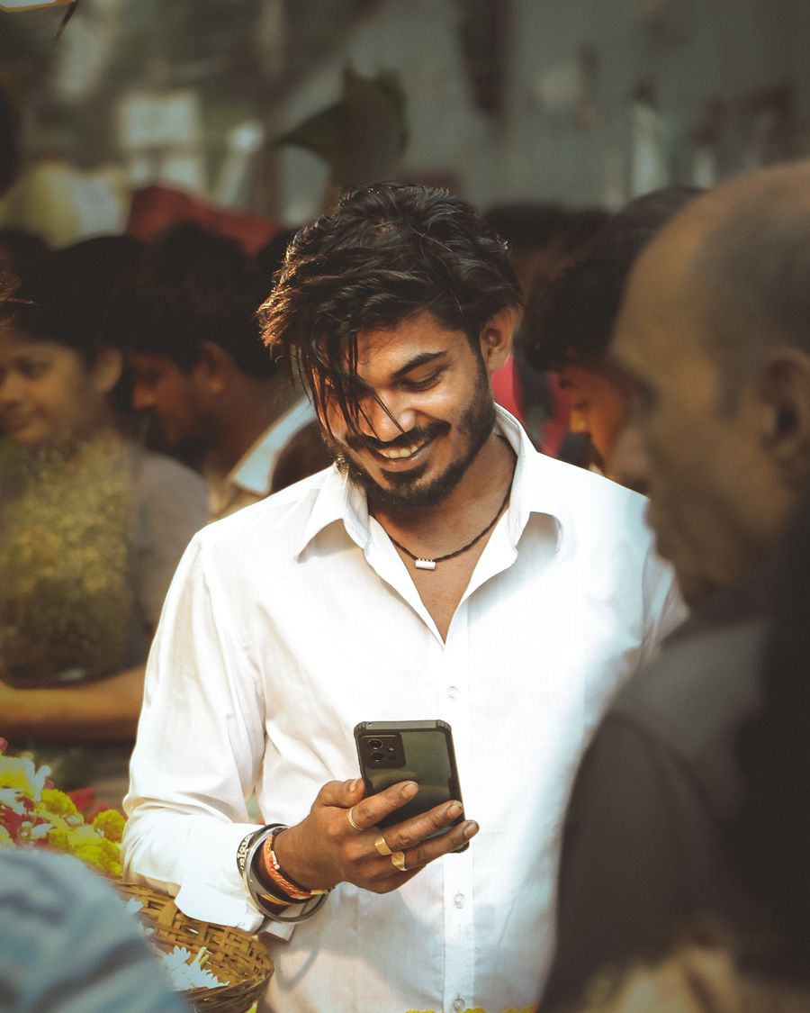 A young man reading his phone and smiling